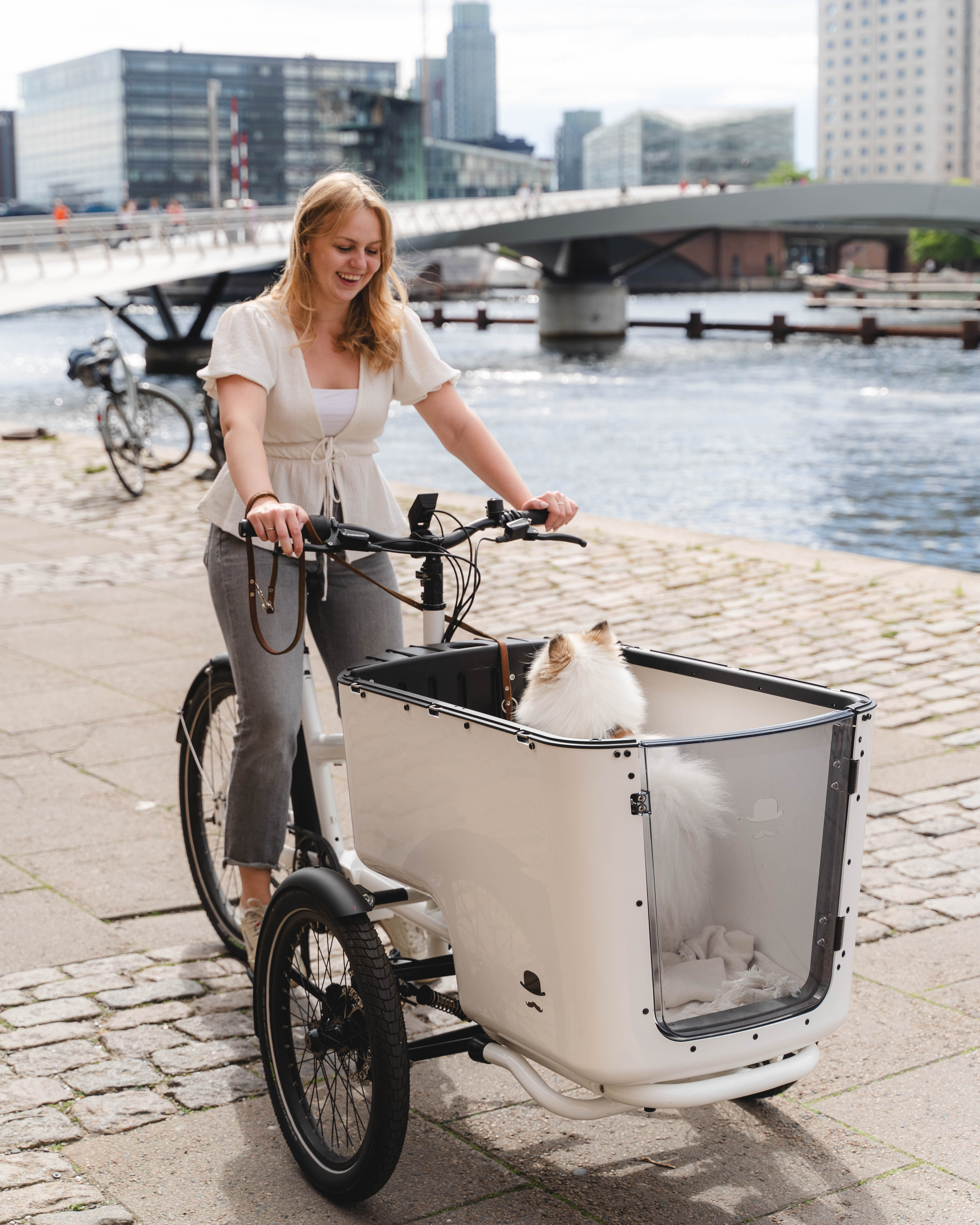 Frau mit Hund im Lastenrad